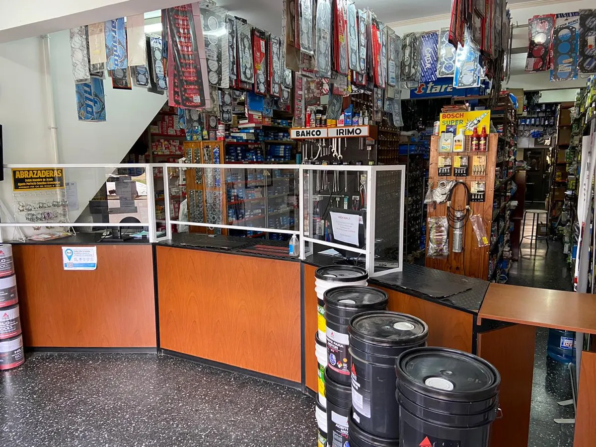 El mostrador del local de repuestos de Casa Vale, con las estanterías cargadas y los baldes de lubricante al frente
